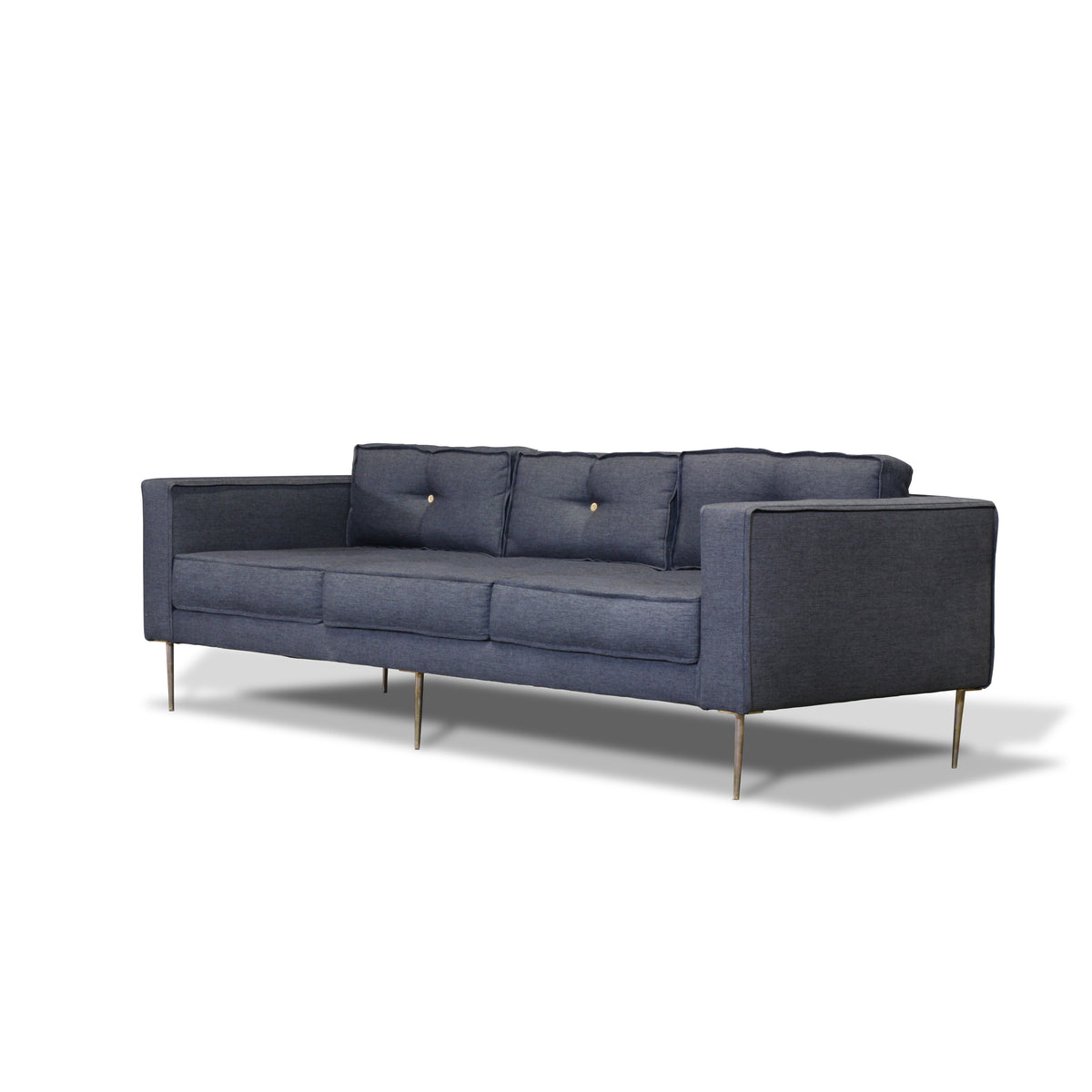 boxy upholstered 3 seater sofa with brass legs and shotgun shell tufting